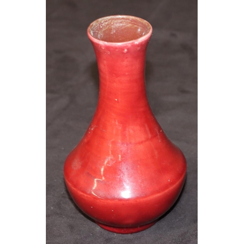 69 - A Liberty small Flambé round bulbous thin necked vase on red ground, 14.5cm high