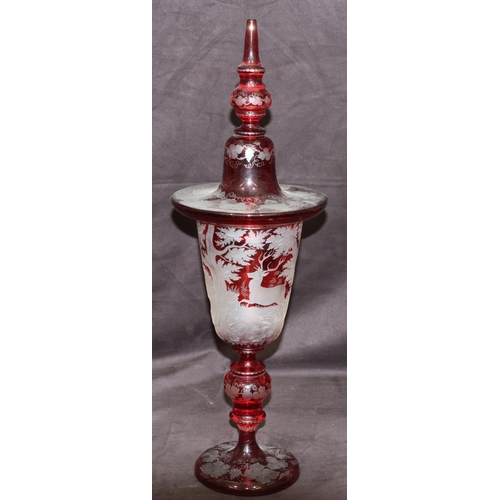 70 - A Bohemian ruby overlay lidded vase with allover etched deer, tree, grape and vine decoration, turne... 