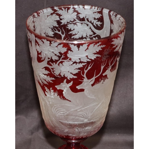 70 - A Bohemian ruby overlay lidded vase with allover etched deer, tree, grape and vine decoration, turne... 