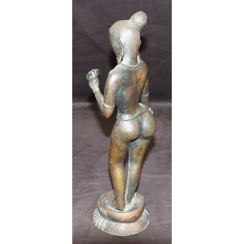 734 - An Eastern bronze figure of a female nude standing holding a petal, on round base, 38cm high