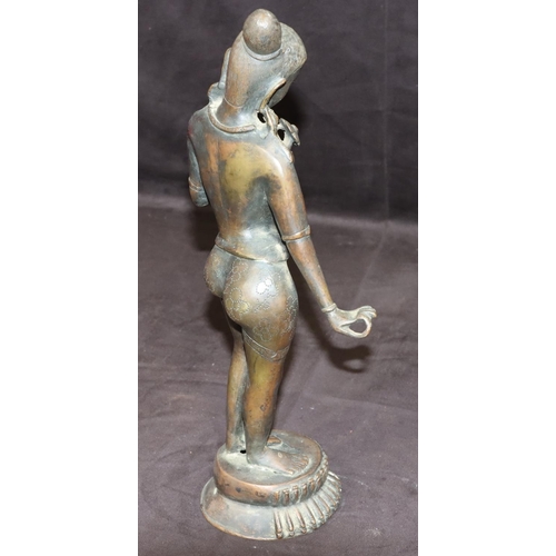 734 - An Eastern bronze figure of a female nude standing holding a petal, on round base, 38cm high