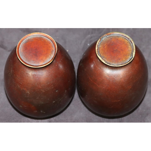 743 - A pair of bronze small round bulbous thin necked vases, 12cm high