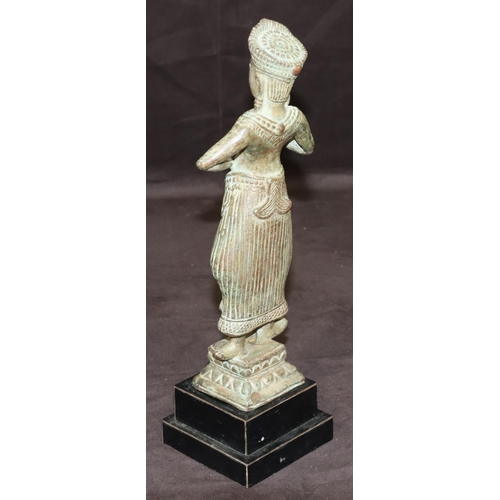 747 - An Eastern bronze figure of a standing lady on square base with further square ebonised platform bas... 