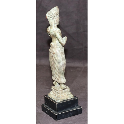 747 - An Eastern bronze figure of a standing lady on square base with further square ebonised platform bas... 