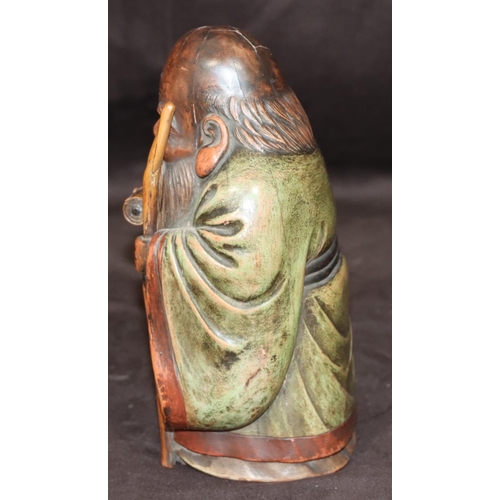 785 - An Oriental carved wooden figure of an elderly standing gentleman holding a staff with green cloak, ... 