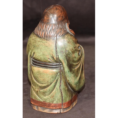 785 - An Oriental carved wooden figure of an elderly standing gentleman holding a staff with green cloak, ... 