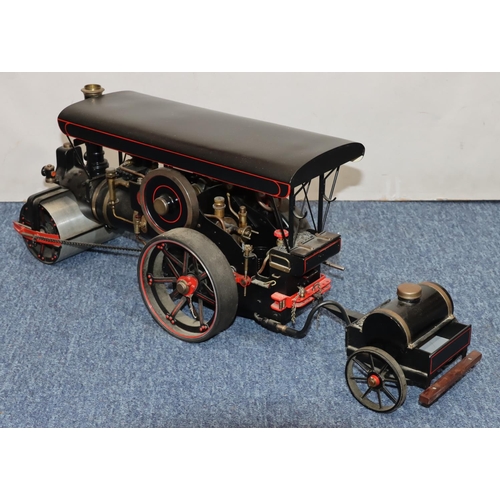 793 - A live model steam traction engine on black ground with separate trailer, gas fired, engine 50cm lon... 