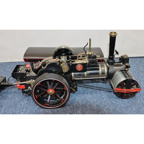 793 - A live model steam traction engine on black ground with separate trailer, gas fired, engine 50cm lon... 