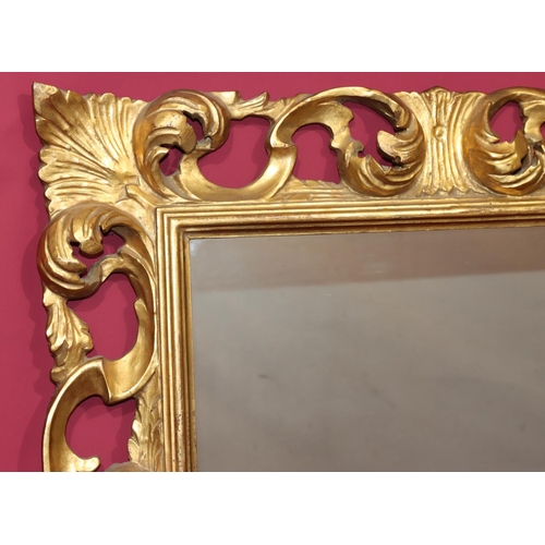 819 - A 20th Century carved giltwood hanging wall mirror with raised and pierced scroll decoration, 83cm h... 