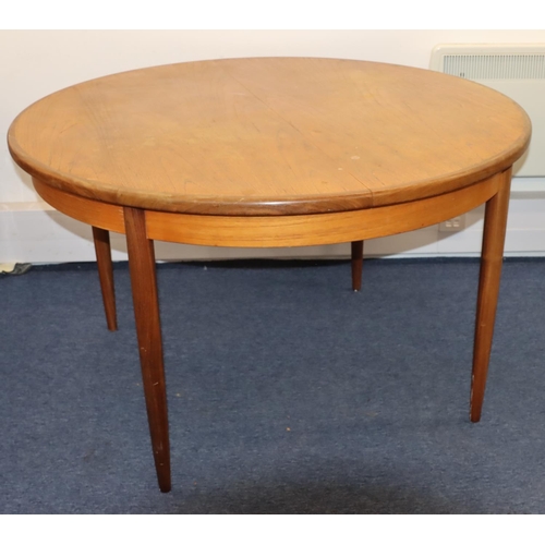 827 - A G-plan circular dining table with extra leaf, on tapering legs, 122cm diameter closed, 168cm open.