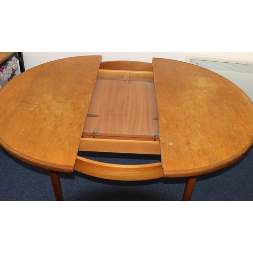 827 - A G-plan circular dining table with extra leaf, on tapering legs, 122cm diameter closed, 168cm open.