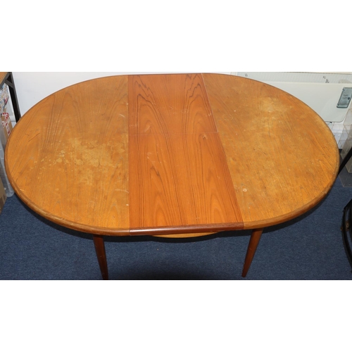 827 - A G-plan circular dining table with extra leaf, on tapering legs, 122cm diameter closed, 168cm open.