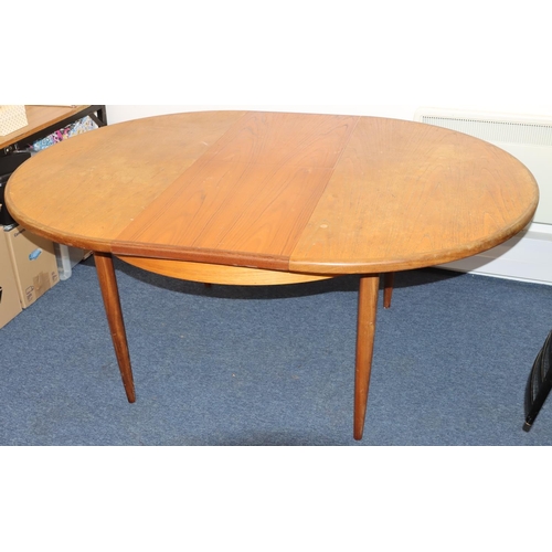 827 - A G-plan circular dining table with extra leaf, on tapering legs, 122cm diameter closed, 168cm open.