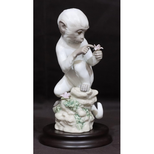 90 - A Lladro figure of a seated monkey holding a flower 