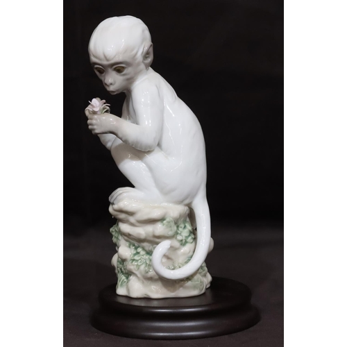 90 - A Lladro figure of a seated monkey holding a flower 