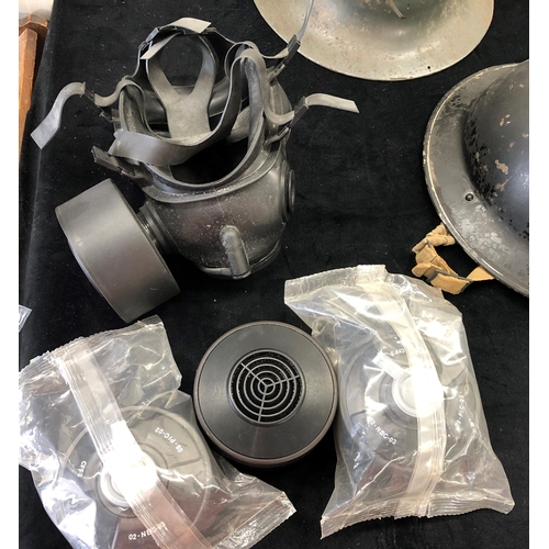 7039 - 4 steel military helmets and a gas mask with additional filters.