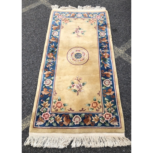 7070 - A wool rug on cream ground with floral pattern, 92 x 183cm (some scattered spots).