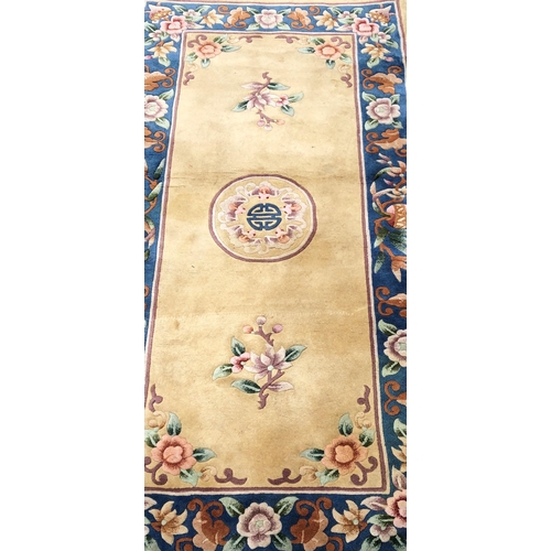 7070 - A wool rug on cream ground with floral pattern, 92 x 183cm (some scattered spots).