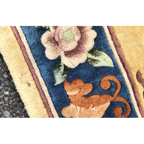 7070 - A wool rug on cream ground with floral pattern, 92 x 183cm (some scattered spots).