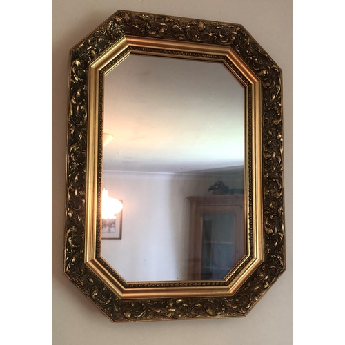 7169 - A small mirror with ornate gilt frame, 40.7cm x 55.8cm.