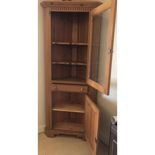 7170 - A pine corner cupboard with upper glazed panel door enclosing 2 shelves, small shallow drawer below ... 