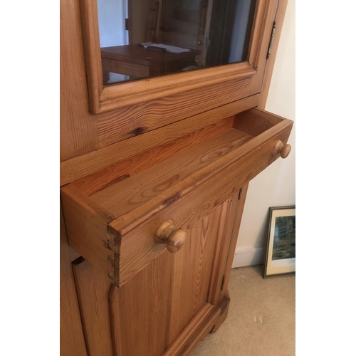 7170 - A pine corner cupboard with upper glazed panel door enclosing 2 shelves, small shallow drawer below ... 