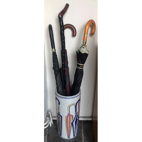 7178 - A glazed umbrella stand, 44cm high and 4 various umbrellas, 1 walking stick and 1 long handled shoe ... 