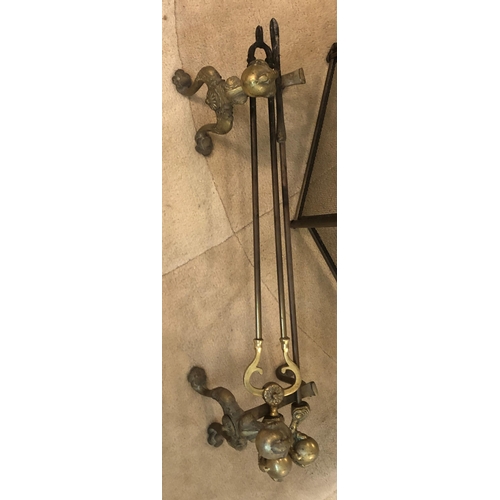 7185 - A 4-sectioned brass fire guard, 81cm high, 130cm wide open and a pair of brass fire dogs with ball a... 