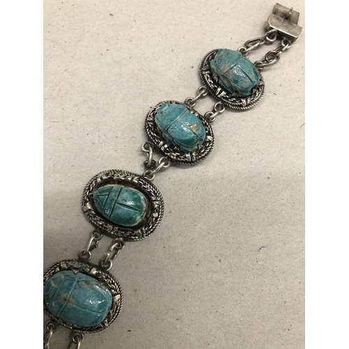 7245 - A silver coloured panel bracelet with blue scarab beetle stones, 19cm long (1 link a/f)