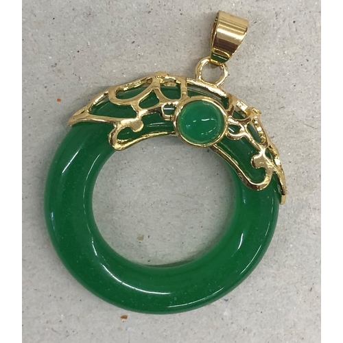 7249 - A green jade circular pendant with gold coloured mount, 4cm long overall