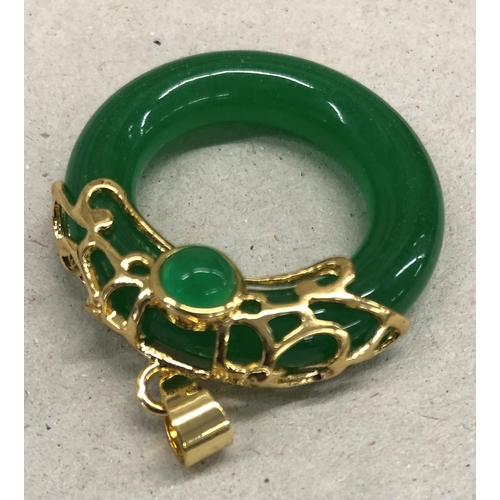 7249 - A green jade circular pendant with gold coloured mount, 4cm long overall