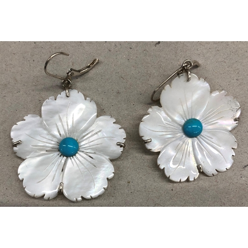 7250 - A pair of Mother of pearl flower shaped earrings with blue stone centres and silver coloured metal m... 