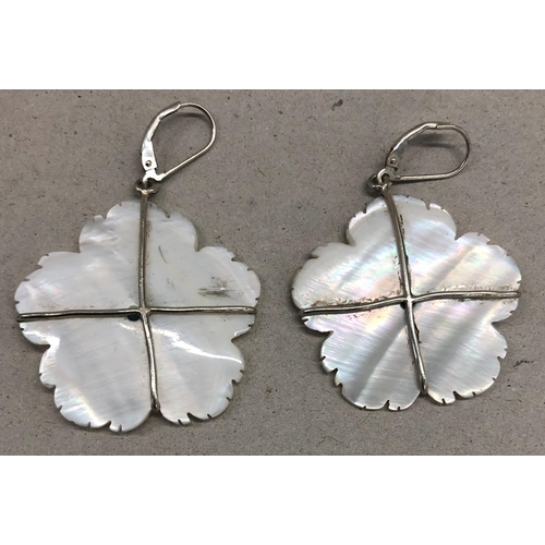 7250 - A pair of Mother of pearl flower shaped earrings with blue stone centres and silver coloured metal m... 