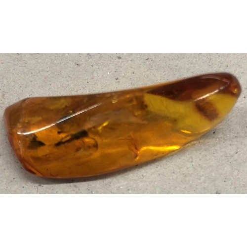 7251 - An amber stone with insect inclusions, 3.5cm long