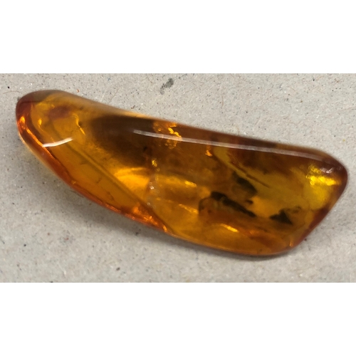 7251 - An amber stone with insect inclusions, 3.5cm long