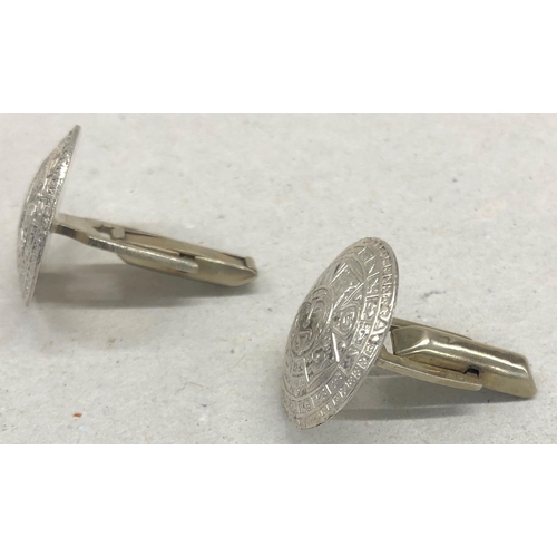 7252 - A pair of circular silver coloured metal Aztec patterned cufflinks, 2cm diameter