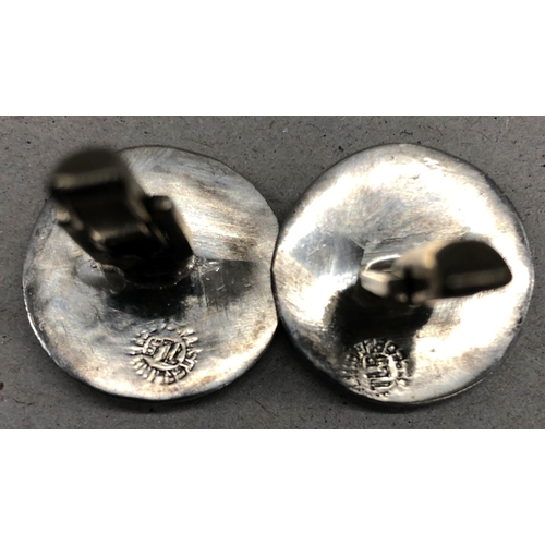 7252 - A pair of circular silver coloured metal Aztec patterned cufflinks, 2cm diameter