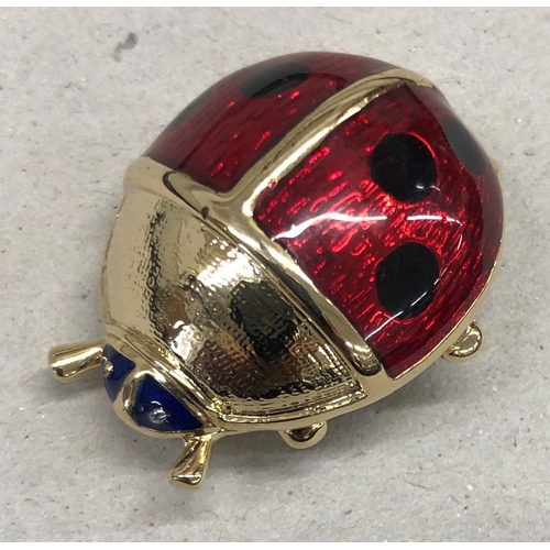 7253 - A red and black enamelled and gold coloured ladybird brooch, 3.5cm wide