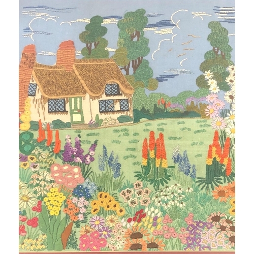 7080 - A hand embroidered picture of a cottage and garden, 34.5 x43cm in wood frame.