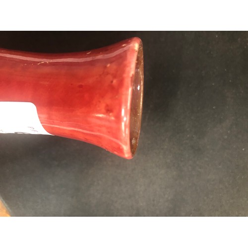 69 - A Liberty small Flambé round bulbous thin necked vase on red ground, 14.5cm high