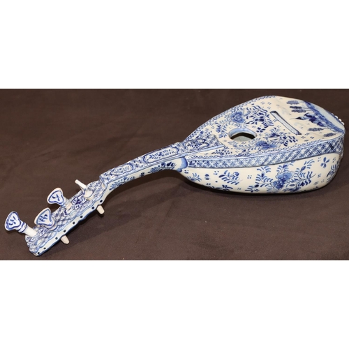 68 - A French Faience Delft style model of a mandolin on blue and white ground with building, floral, lea... 