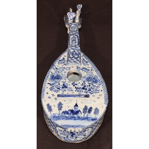 68 - A French Faience Delft style model of a mandolin on blue and white ground with building, floral, lea... 