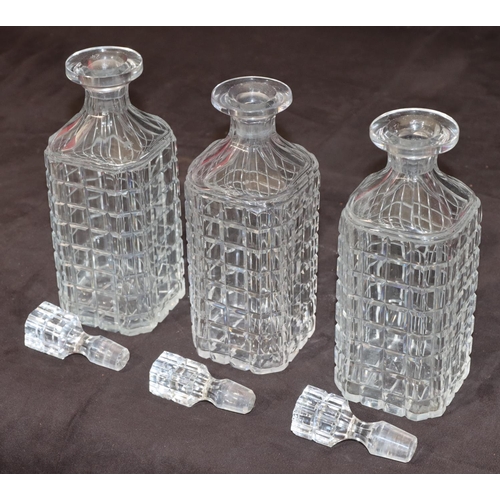 27 - A set of 3 cut glass square decanters with thumb pattern necks and stoppers, 23cm high