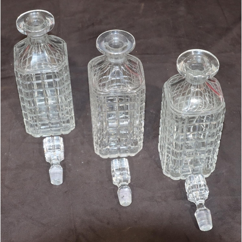 27 - A set of 3 cut glass square decanters with thumb pattern necks and stoppers, 23cm high