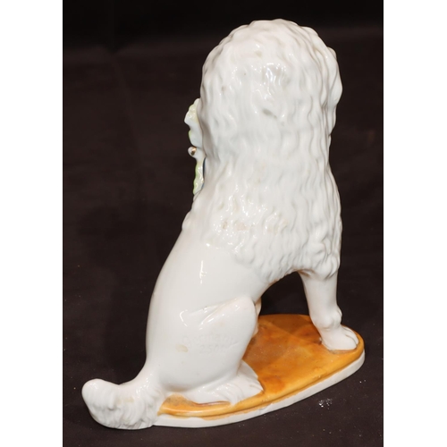 46 - A Bisque Staffordshire style figure of a seated spaniel holding basket in its mouth, 19cm high