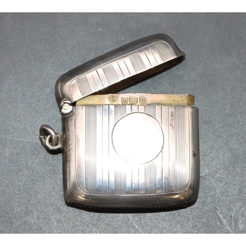 225 - A George V silver concave shaped vesta case with engine turned decoration and hinged lid, Birmingham... 