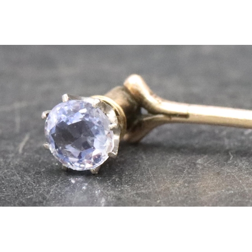 396 - A gold stickpin mounted with a pale blue stone, 1.6 grams gross