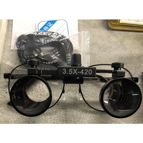 8063 - A pair of Magnifier glasses 3.5X-420, with instructions, cased, a Europa travelling alarm clock, a m... 