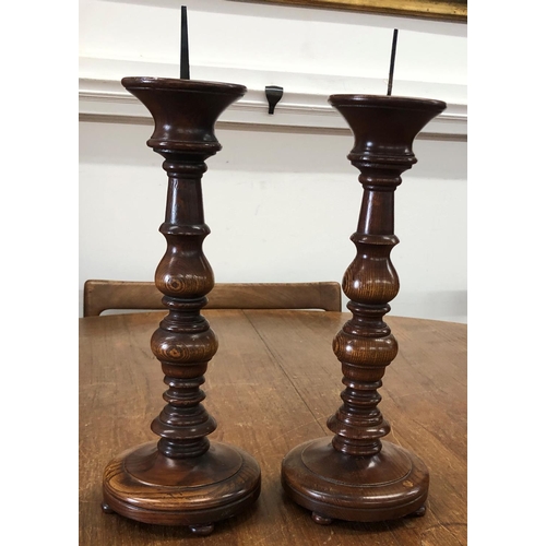 8289 - A pair of oak candlesticks, 41cm high overall.