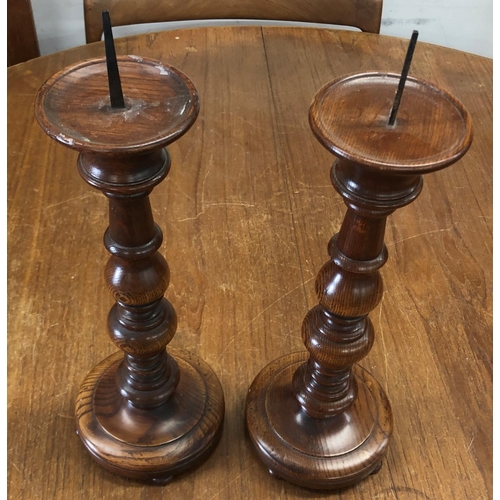 8289 - A pair of oak candlesticks, 41cm high overall.